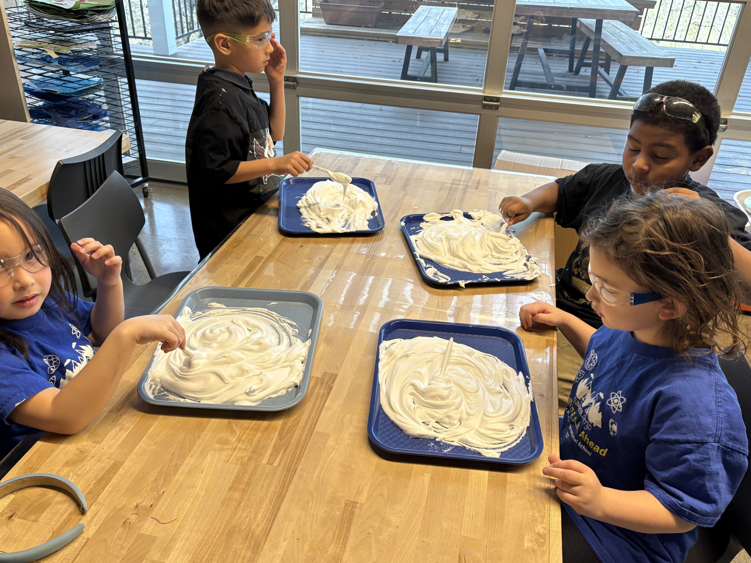 Students collaborating on a science experiment or mixture activity, showing CIS's inquiry-based curriculum approach