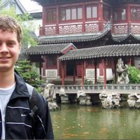 Matt Holt stands in front of a koi pond and building in Yiwu, China