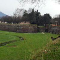 Ruth Wels sitting on a green hillside in Italy