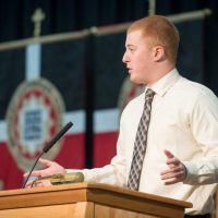 Jacob Schneider speaking from a podium