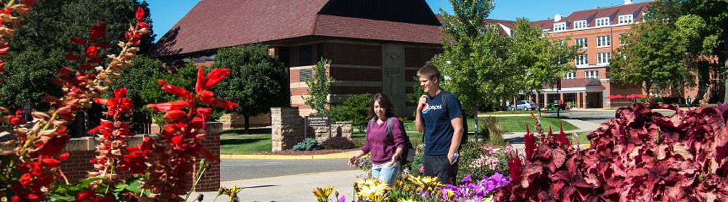 Two Bethany students walking across campus with Trinity Chapel in the background