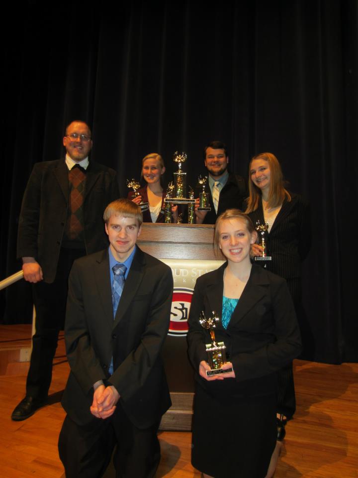 Speech team on stage with trophies