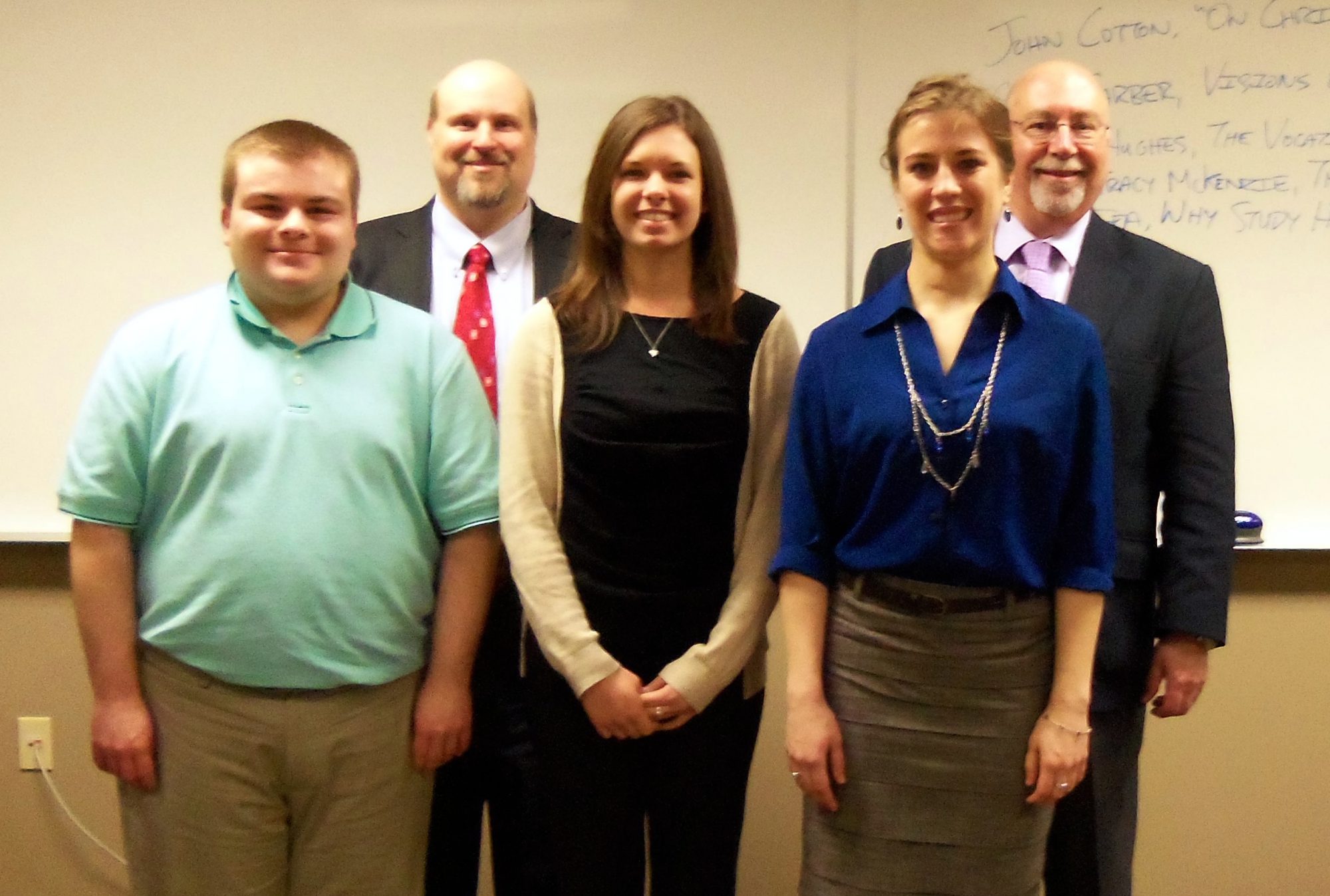 students and professors in front of whiteboard at history symposium