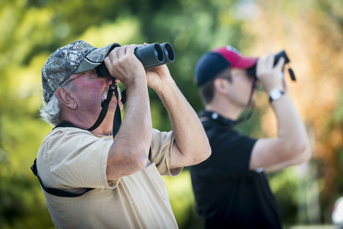 Two birdwatchers use binoculars to view and count hawks as part of Bethany's Hawkwatch