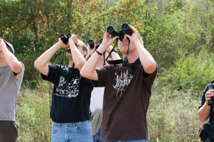 students with binoculars watching and counting hawks