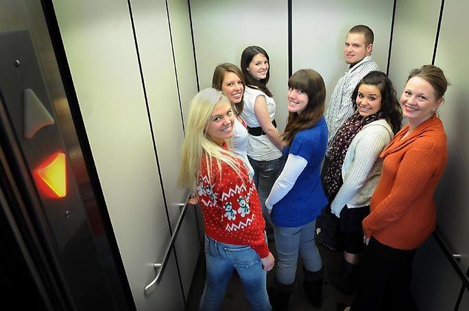 students in an elevator turning and looking at camera