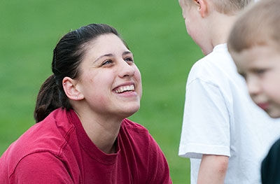 female student smiles at young child