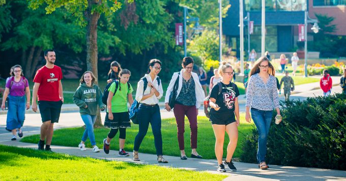 Students and staff walk across campus