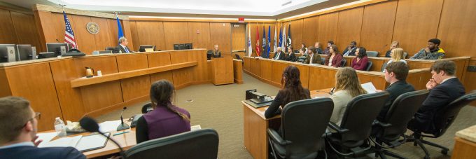 Legal studies students carry out a mock trial in a courtroom.