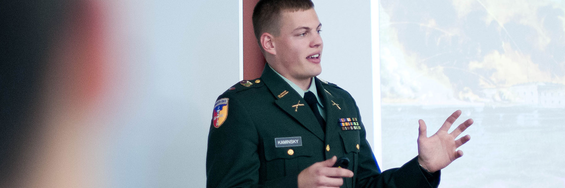 man in military uniform speaking to a group