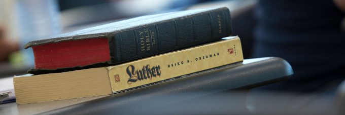 The Holy Bible on top of a book titled "Luther" on a desk