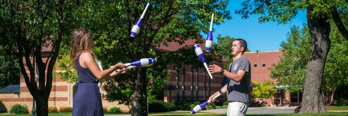 Students on campus green practice their juggling skills