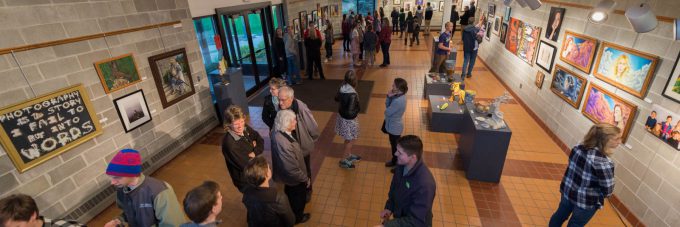 Visitors look around the Ylvisaker Fine Arts Center Gallery during a student art show