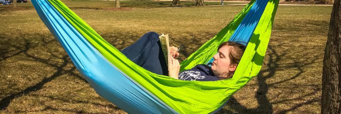 Female student reads in a hammock