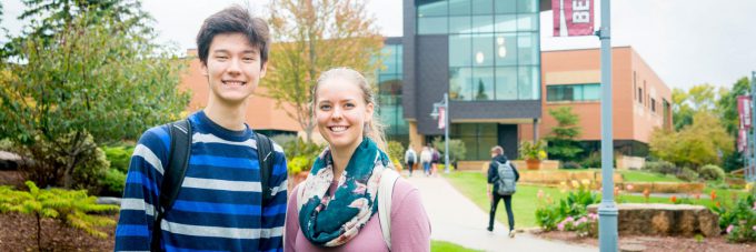 Two students pose for photo in front of Honsey Hall