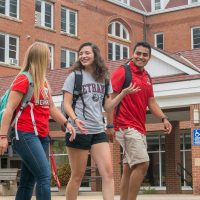 Students walking by Old Main and talking