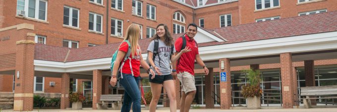 Students walking by Old Main and talking