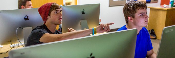 Student asking question in computer lab classroom