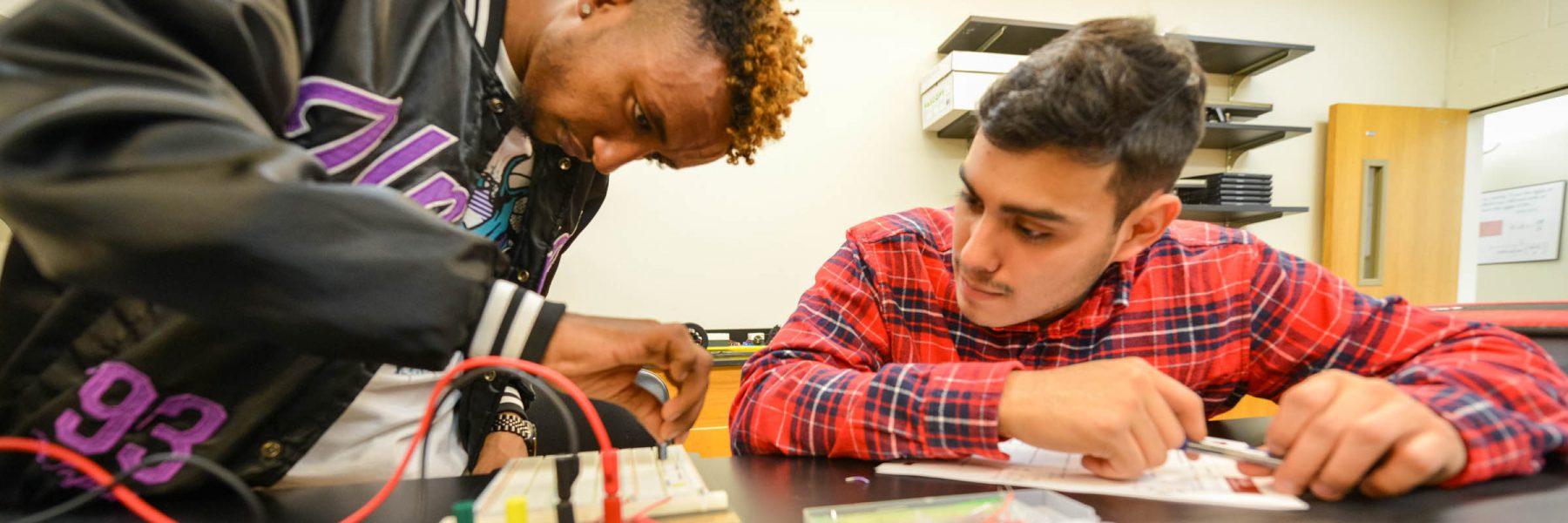 Students during physics class assemble and test a circuit board