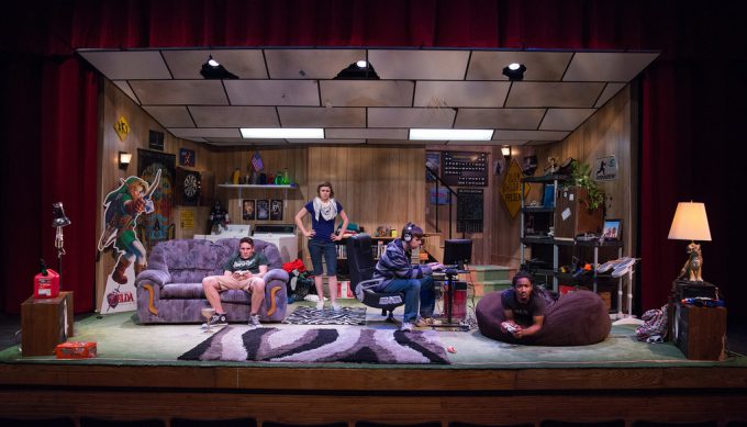 Stage is designed to look like a basement family room with furniture, gaming systems, stereo, etc. 4 actors on stage.