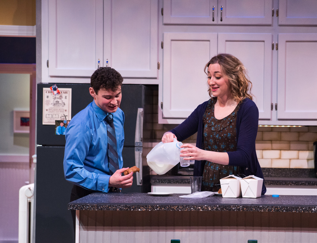 Two characters (male and female) in the kitchen at the counter.