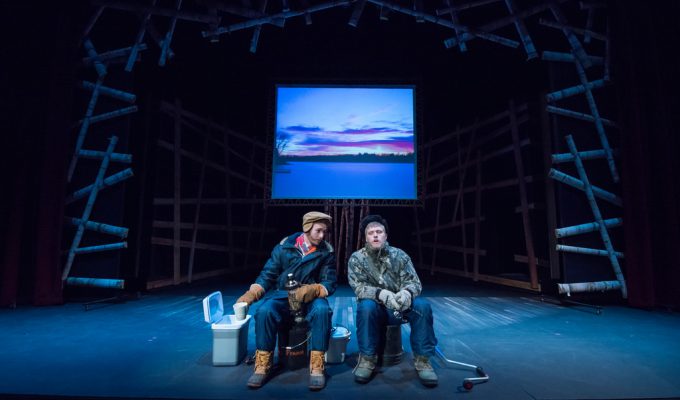 Two actors sitting on buckets and dressed for ice fishing, pretend to be sitting on a lake and ice-fishing