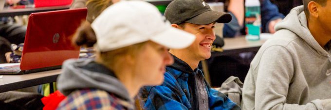 Student in cap smiling during class