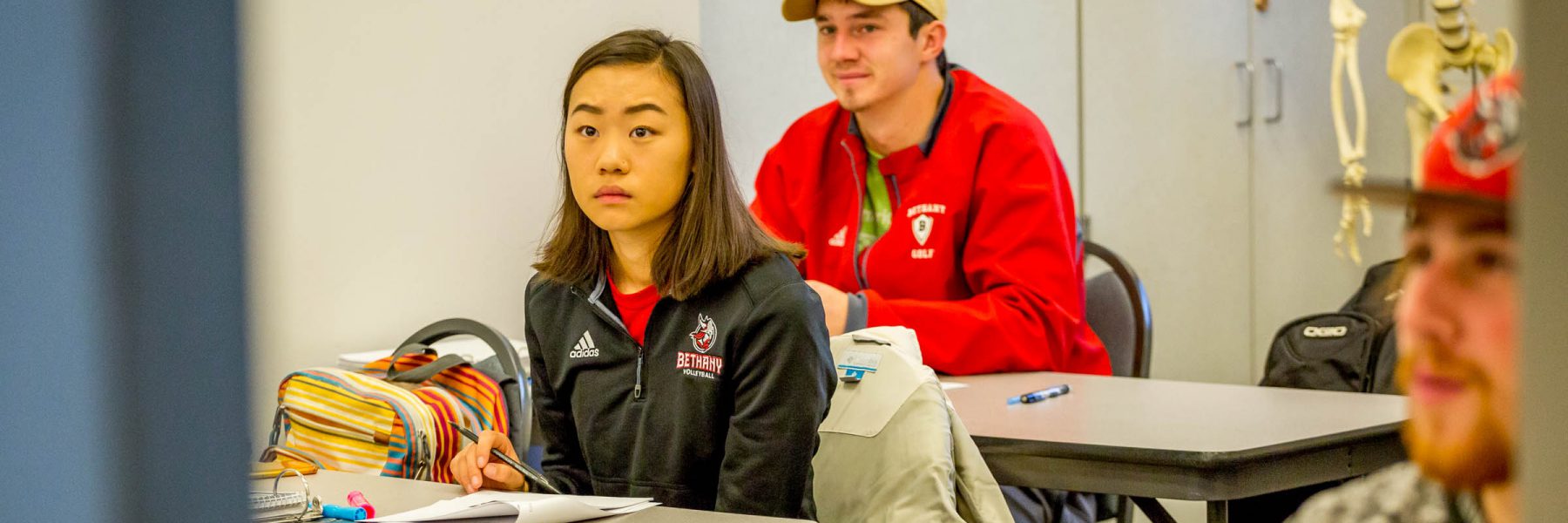 Students at tables, listening to speaker