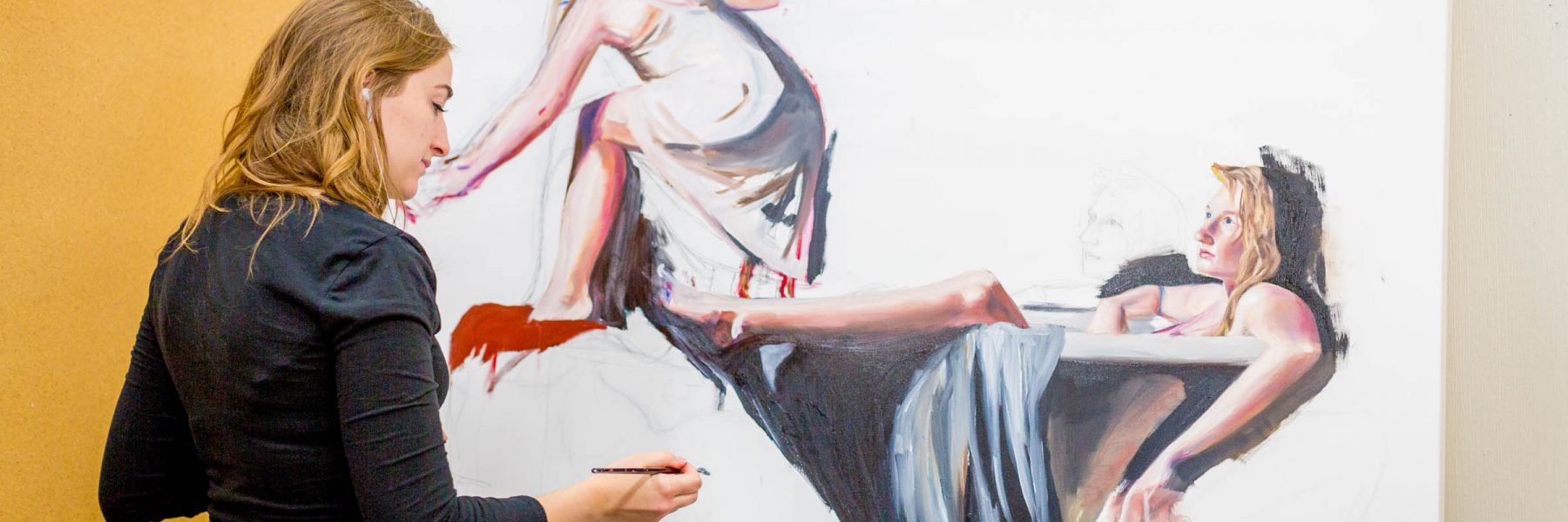 Female art student paints on large canvas