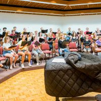 Prof. Dennis Marzolf directs a Bethany Concert Choir practice as they sing a hymn in Bethany's Silber Hall.