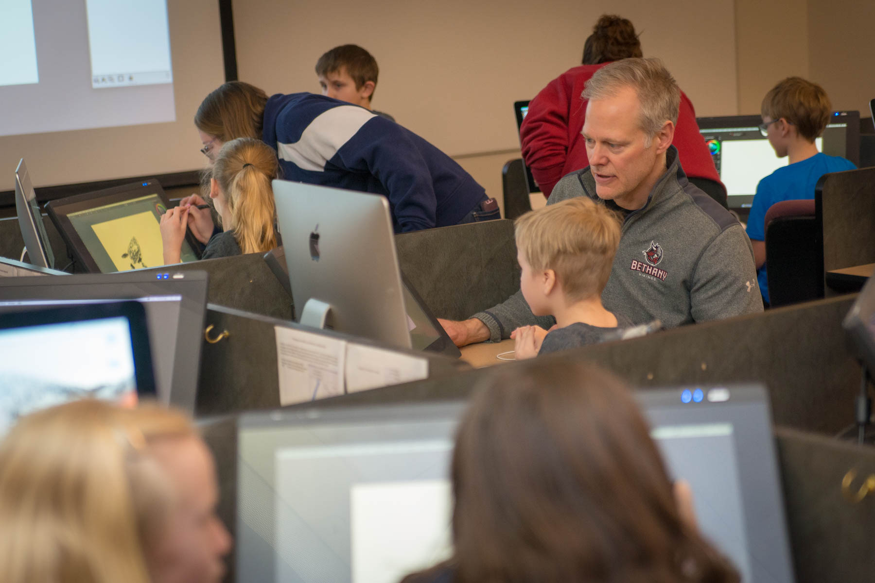 Professor Overn helps elementary students use the computers