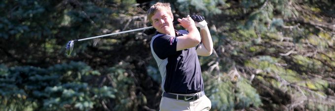 A Bethany Vikings Men's Golf player takes a swing on the course.