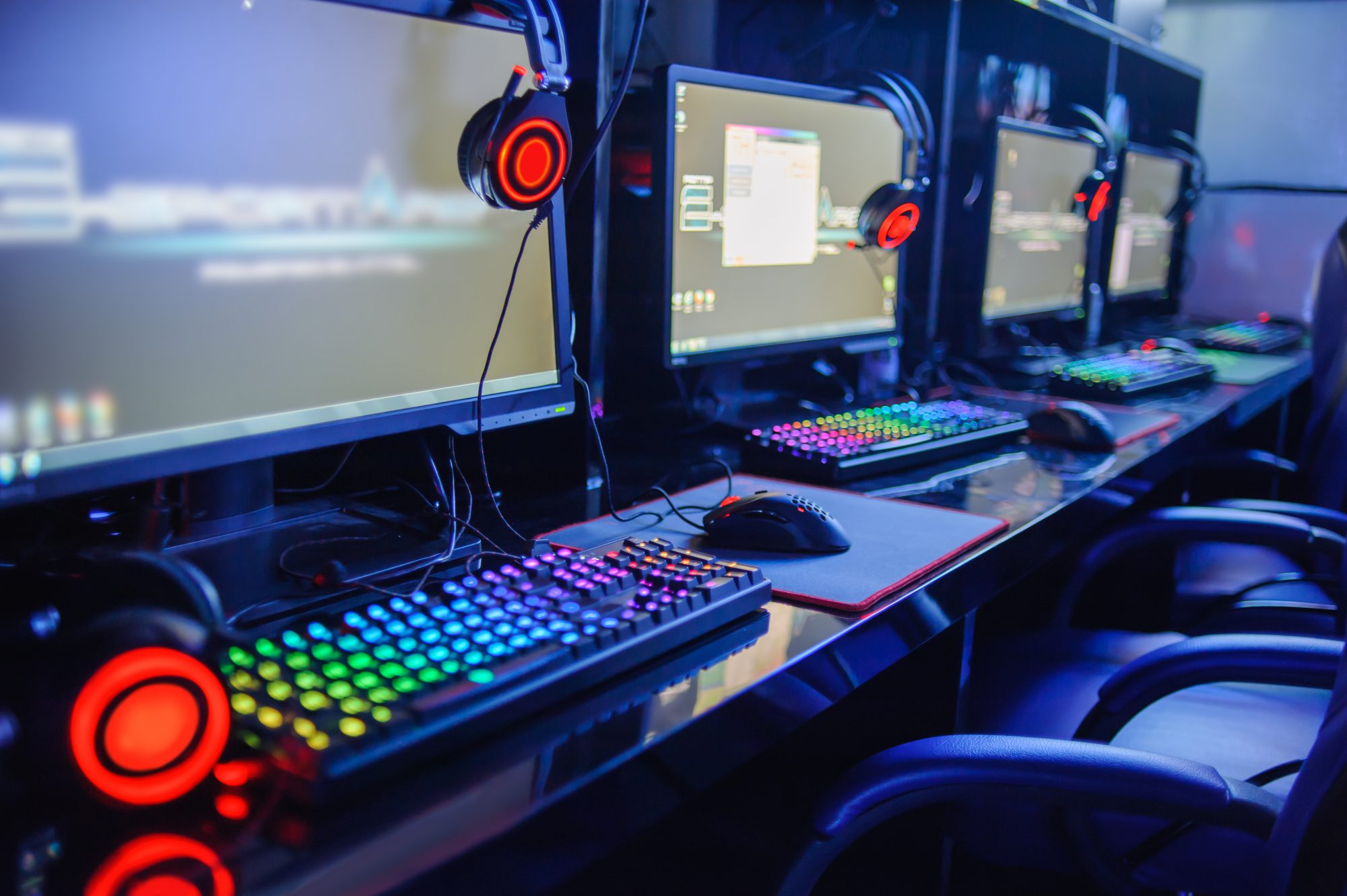 Group of eSports gaming computers show off their colorful keyboards and headphones