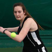 A tennis player prepares to hit an incoming ball.