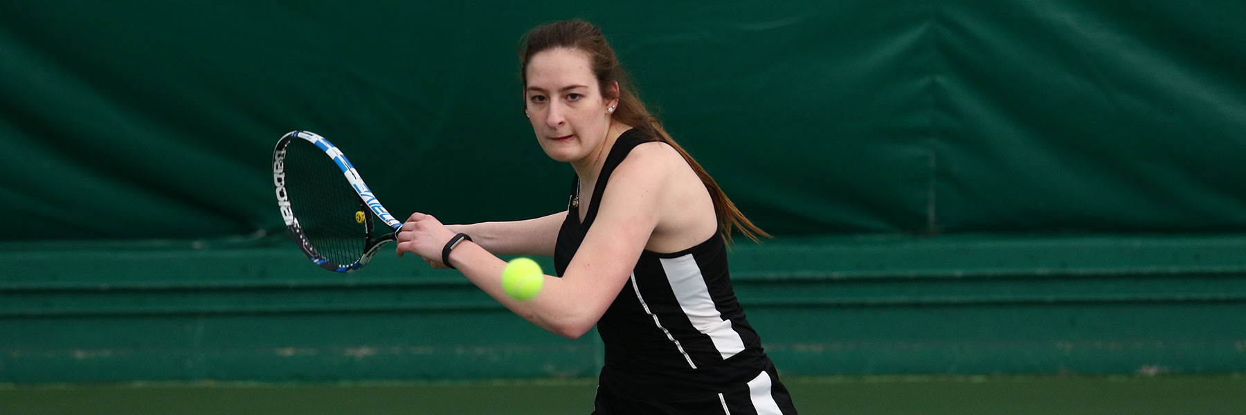 A tennis player prepares to hit an incoming ball.