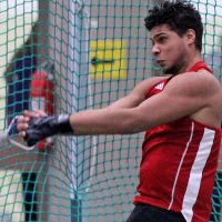 A student participates in a hammer throw during a track and field meet.