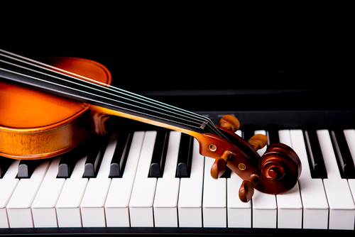 Violin lying across piano keys