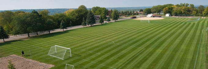 Grass field with soccer goals outside on a sunny day