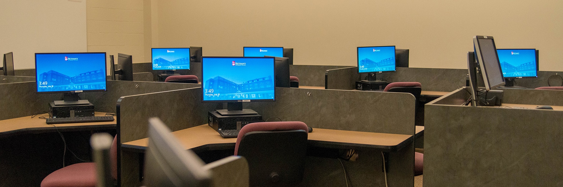 computer monitors set out on desks in a lab