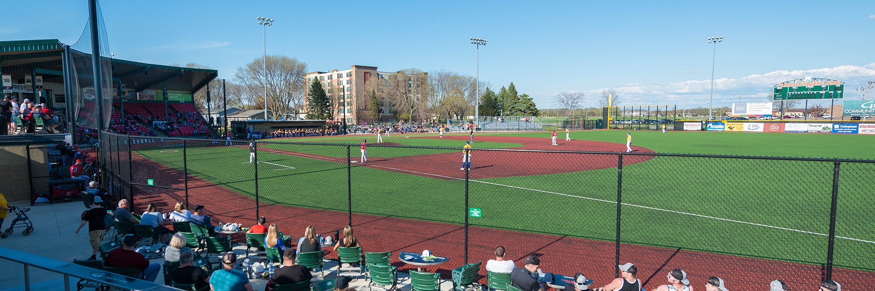 baseball field with players and fans as seen from the outfield