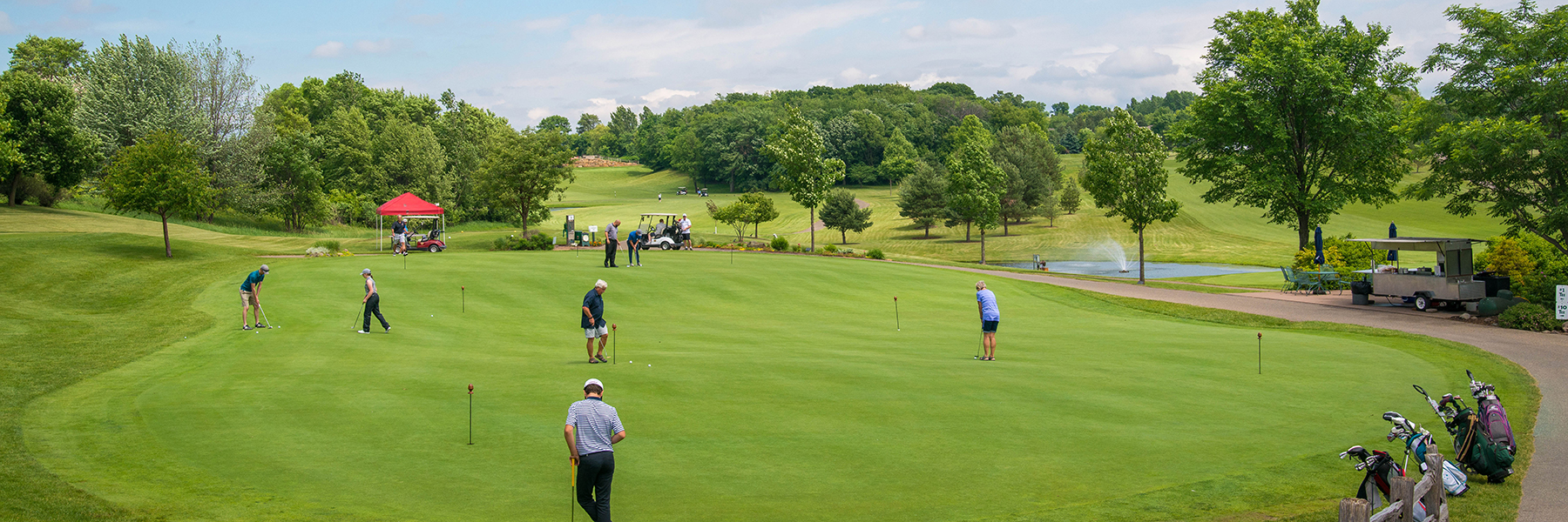 golfers practice putting on a putting green before a tournament