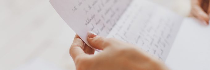 hand written letter held by womans hands