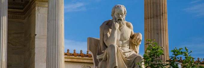 Image of ancient statue of the great Greek philosopher Socrates on background of classical columns.