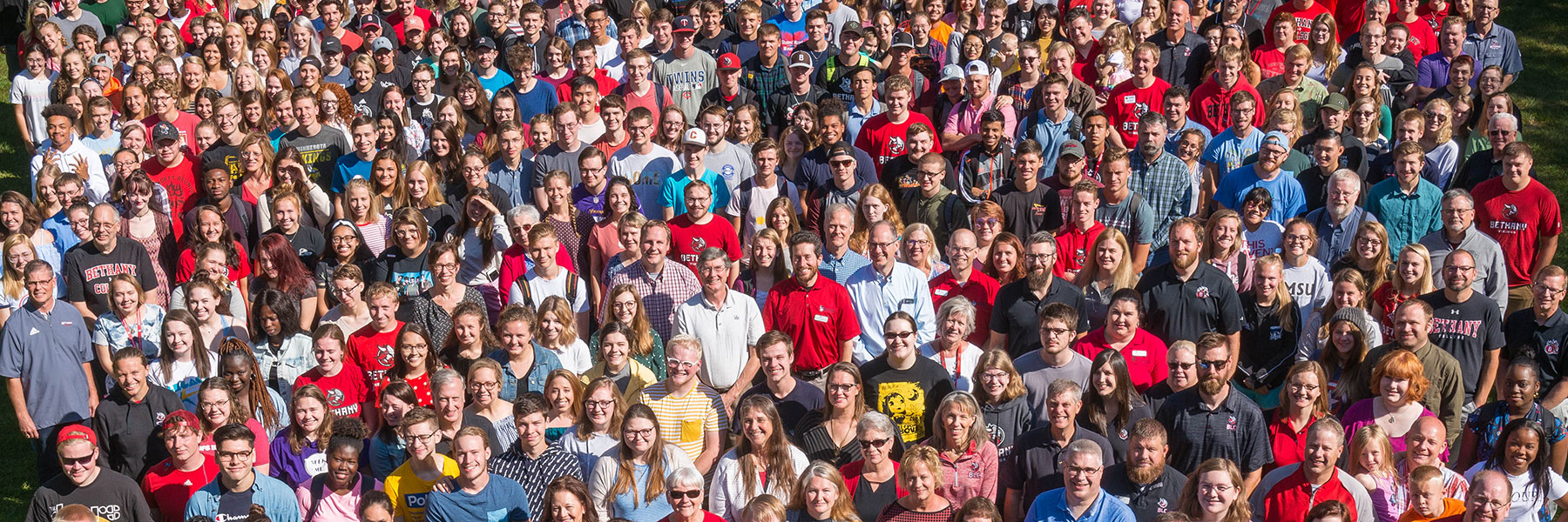 large crowd of people together looking right at camera on a sunny day