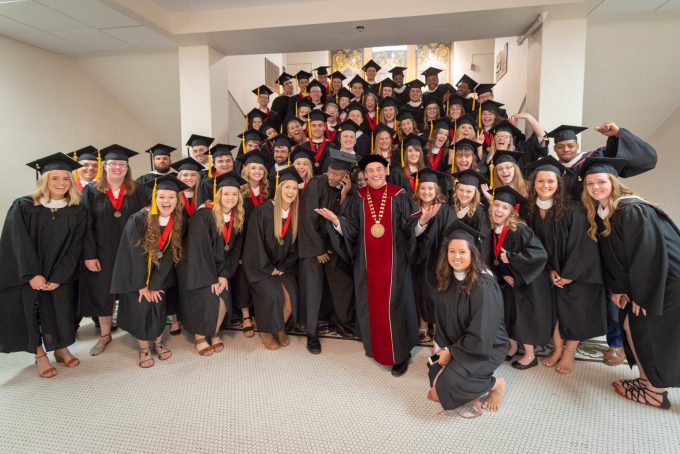 BLC President Dr. Gene Pfeifer stands with the Spring 2018 graduating class on the stairs in Old Main just before the commencement ceremony begins.