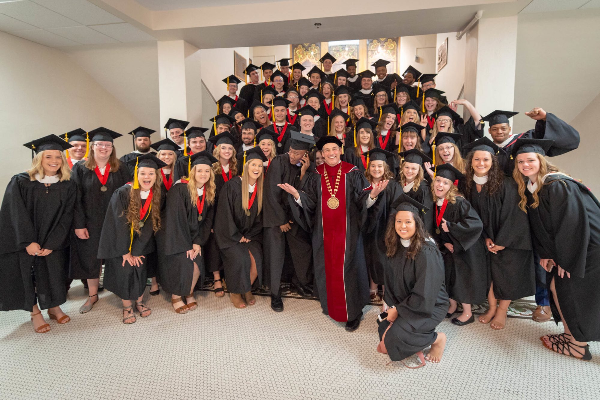 BLC President Dr. Gene Pfeifer stands with the Spring 2018 graduating class on the stairs in Old Main just before the commencement ceremony begins.