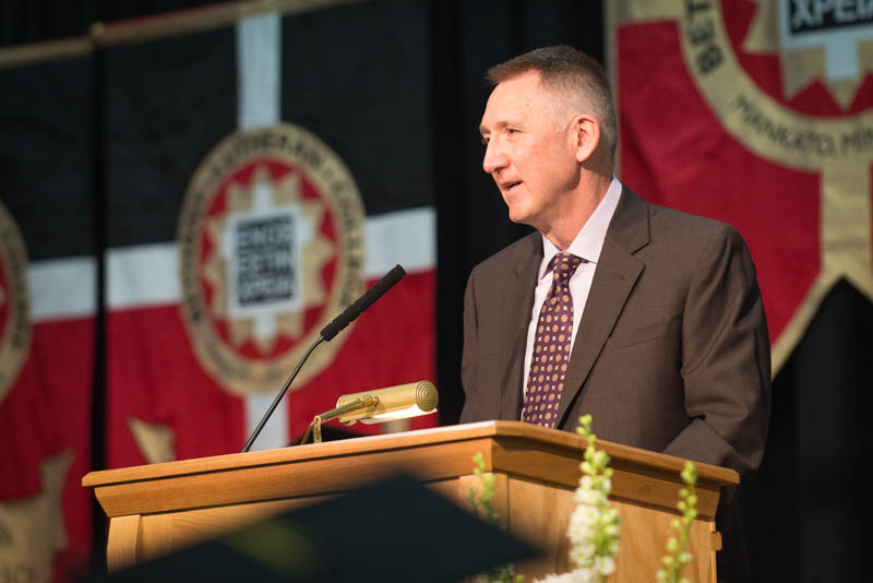 Jim Vinz speaks at a podium at the 2015 commencement ceremony.