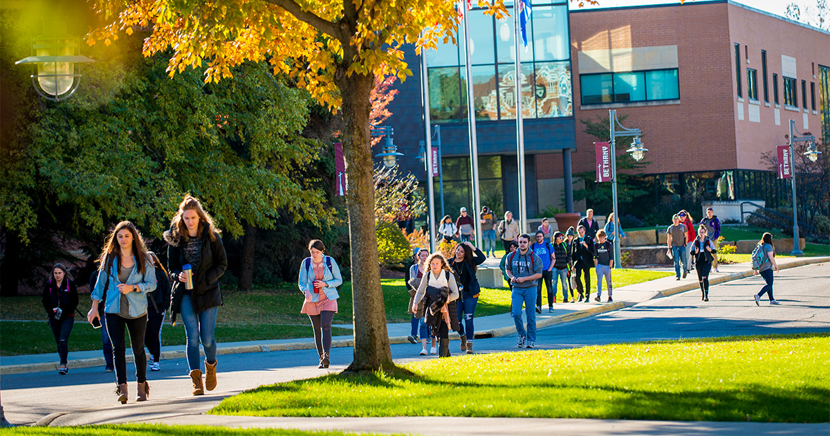 photo of students walking around campus on a sunny day