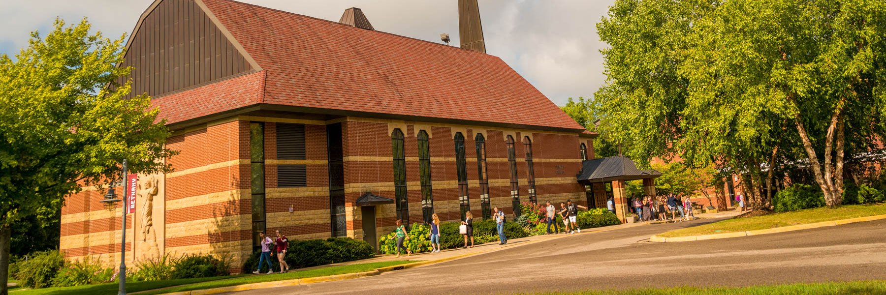 students exiting out of out trinity chapel and walk along the sidewalk