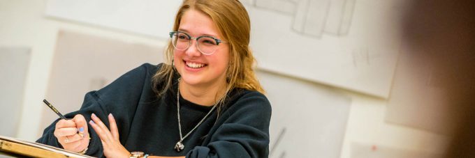 a female students laughs during a drawing class